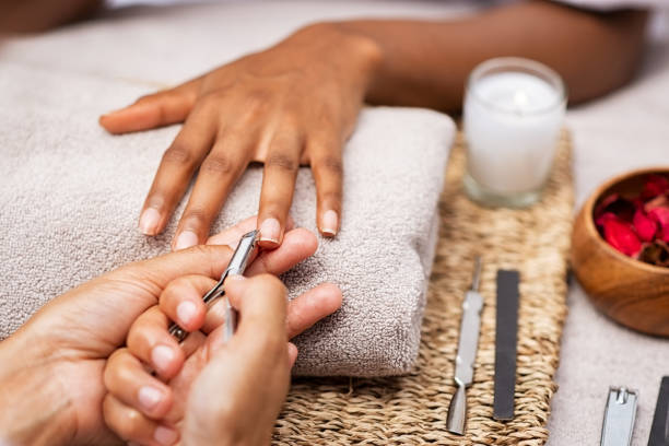 istockphoto-1176487598-612x612 Close up of manicurist hands clipping client nails in a luxury spa. Young woman getting manicure treatment with hands kept on towel. "rClipping nails, hand care and nailcare at beauty salon.